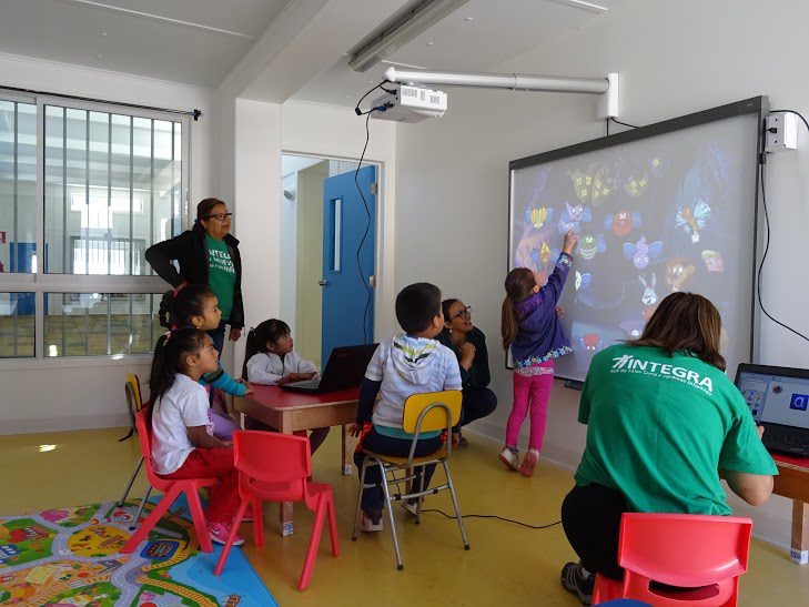 Niñas y niños participan activamente en pizarra interactiva del Jardín Infantil.